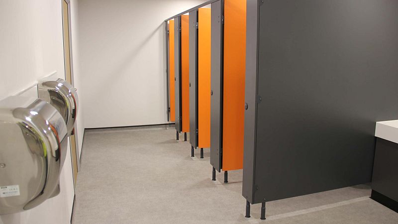 Orange toilet cubicles and hand dryers